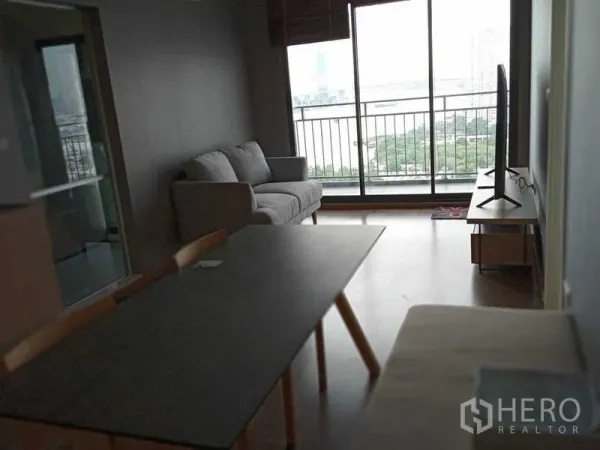 คอนโด ให้เช่าในYan Nawa, Bangkok - ห้องนั่งเล่นแบบโอเพ่น มีโซฟา โต๊ะทานข้าว และทีวี เปิดสู่ระเบียงวิวแม่น้ำ