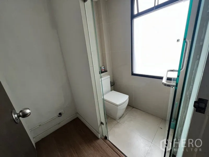 ทาวน์เฮาส์ ให้เช่าหรือขายในKhlong Toei, Bangkok - ห้องน้ำแขกพร้อมโถสุขภัณฑ์ ฉากกั้นอาบน้ำกระจก และหน้าต่างฝ้า