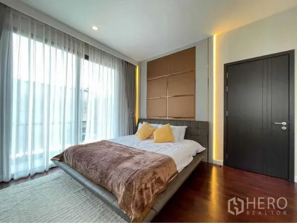 Detached House for rent in Bang Sue, Bangkok - Sunny bedroom with floor-to-ceiling curtains and feature wall panels.