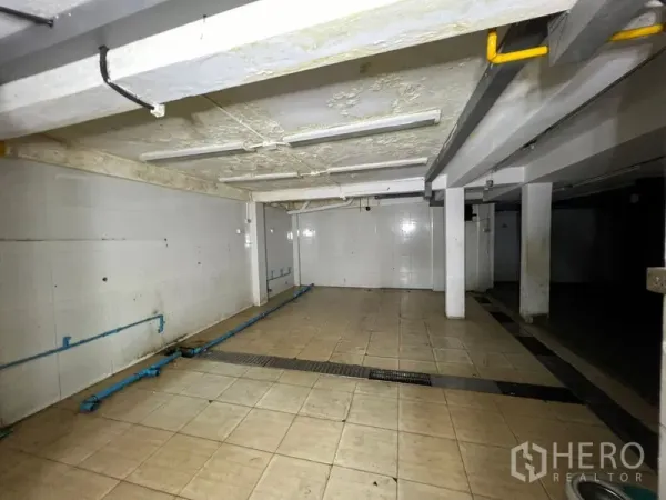 零售空间 出租在Din Daeng, Bangkok - 后勤瓷砖房，带立柱、地沟和外露管线，可作储物或设备间。