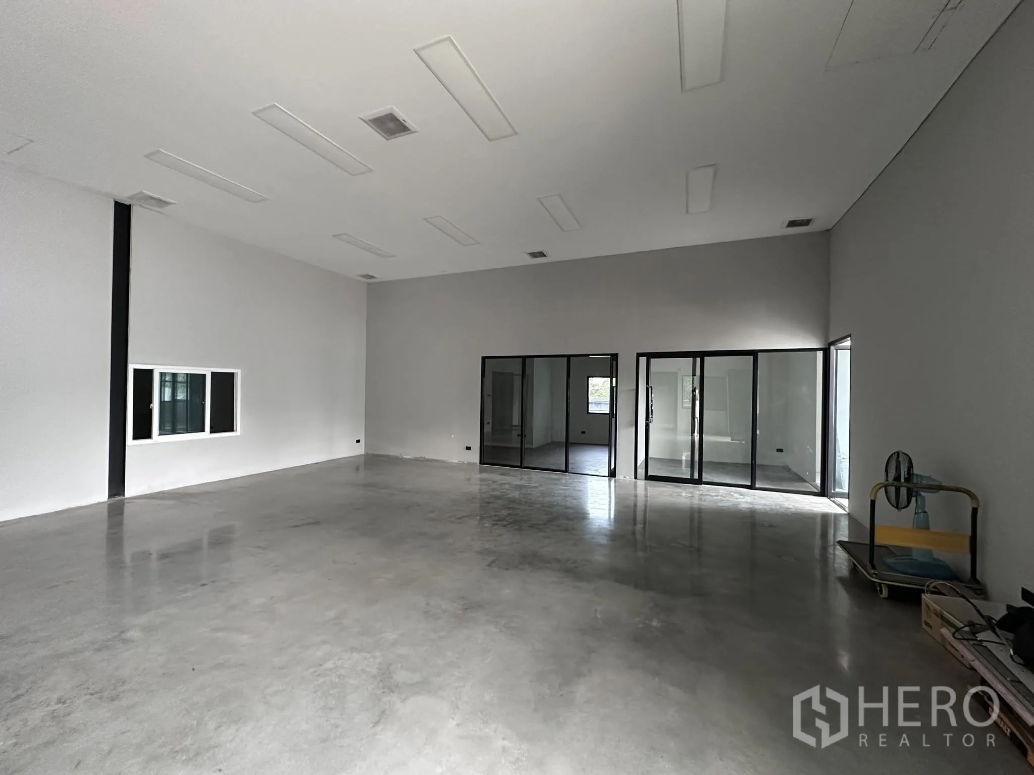 Warehouse for rent or sale in Prawet, Bangkok - Large open warehouse hall with lighting panels and steel support columns.