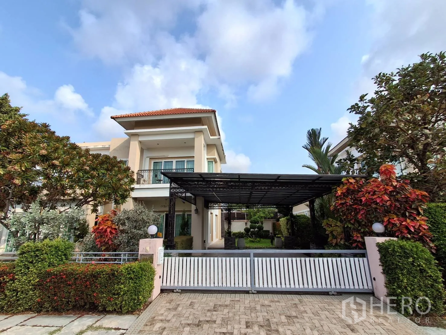 Detached House for rent or sale in Ban Chang, Rayong - Front view of a two-storey detached house with balcony, covered carport and sliding gate.