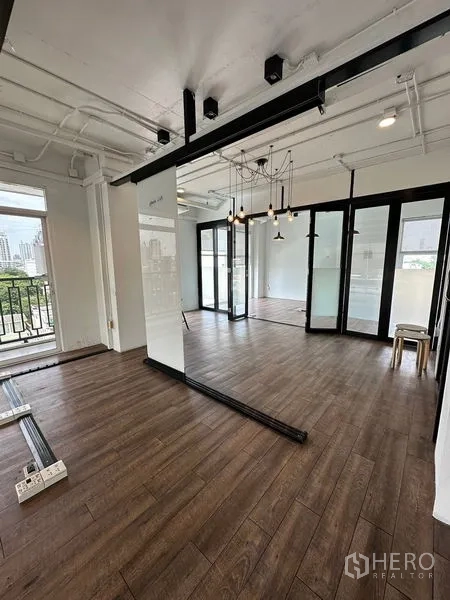 办公空间 出租在Watthana, Bangkok - 工作区配滑动玻璃门、外露天花管线、吊灯及阳台通道。