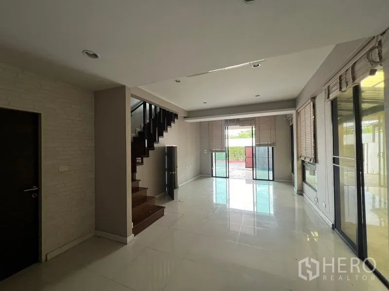 ทาวน์เฮาส์ ให้เช่าหรือขายในKhlong Toei, Bangkok - โถงนั่งเล่นแบบโอเพ่นพร้อมพื้นกระเบื้องเงา บันได และประตูกระจกกว้าง