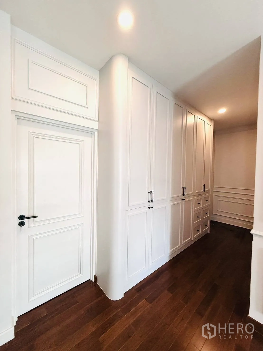 Detached House for rent in Wang Thonglang, Bangkok - Bright hallway with white built-in cabinetry and warm wooden flooring.
