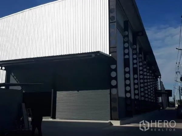 คลังสินค้า ให้เช่าในKhlong Sam Wa, Bangkok - ด้านนอกโกดัง ผนังเมทัลชีท เสาเหล็ก และประตูม้วนโหลดสินค้า