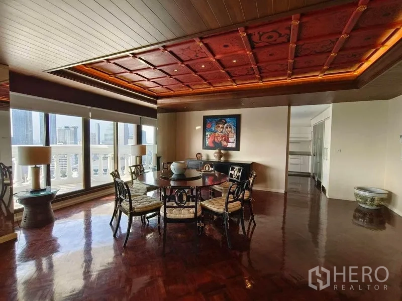 Condominium for rent in Bang Rak, Bangkok - Elegant dining room with red coffered ceiling, round table, and city views from large windows.