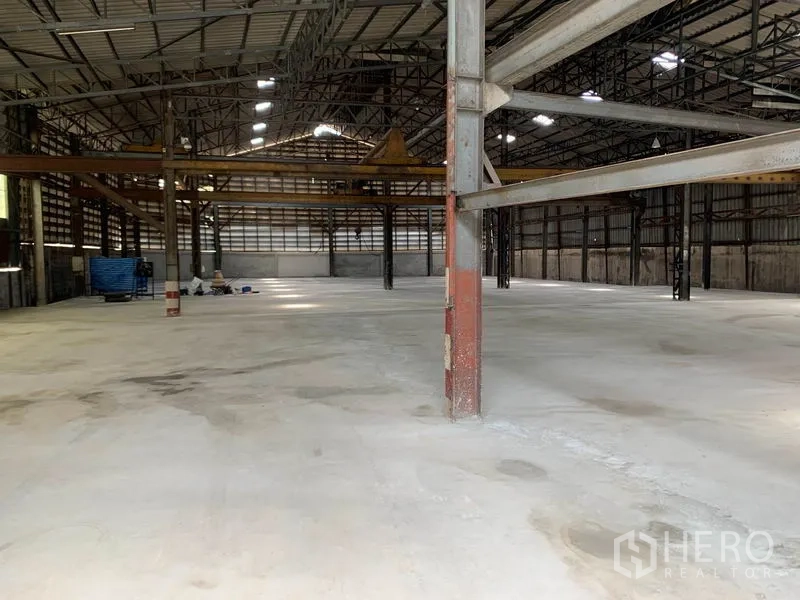 Warehouse for rent in Yan Nawa, Bangkok - Open-plan warehouse floor with crane beams and ample artificial lighting.
