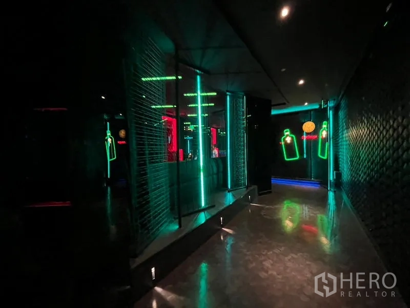 零售空间 出租在Ratchathewi, Bangkok - 走道设绿色LED灯条、纹理墙与镜面隔断。