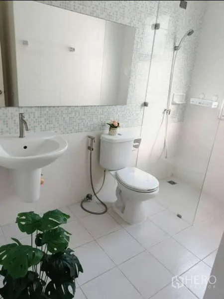 联排别墅 出租在Bang Kapi, Bangkok - 明亮浴室，玻璃隔断淋浴、马桶和大镜面。