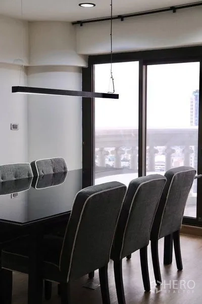 公寓 出租在Bang Rak, Bangkok - 餐区，玻璃餐桌、四把椅子与推拉门通向阳台。