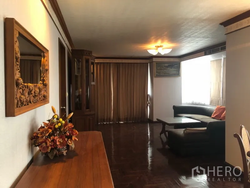 คอนโด ให้เช่าในKhlong Toei, Bangkok - ห้องนั่งเล่นพื้นปาร์เกต์ โซฟา L-shape ตู้ไม้ และผ้าม่าน