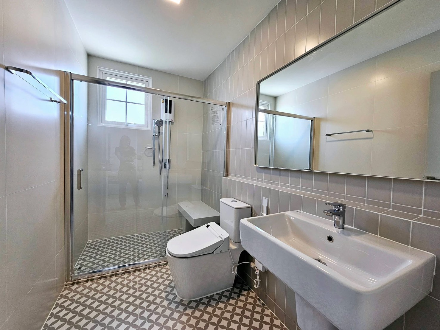 Detached House for rent in Bang Phli, Samut Prakan - Modern bathroom with glass-enclosed shower, large mirror, and patterned floor tiles.