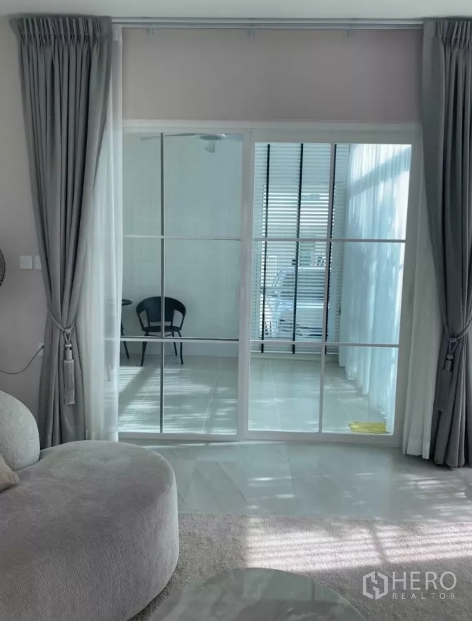 Detached House for rent in Bang Phli, Samut Prakan - Enclosed terrace or sunroom behind white-grid sliding glass doors.