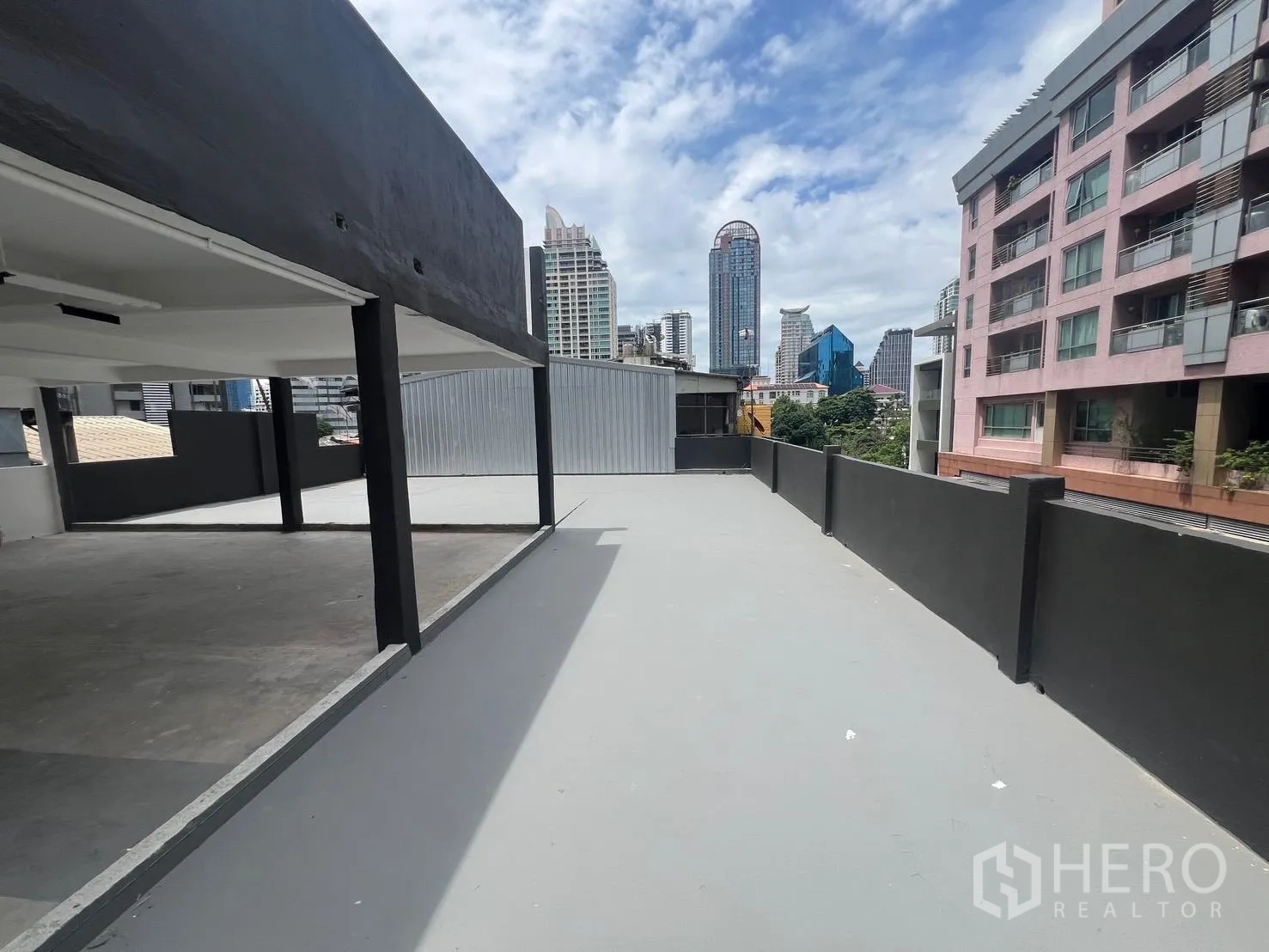 พื้นที่ขายของ for rent in Bang Rak, Bangkok - ทางเดินดาดฟ้าและระเบียงยาวข้างอาคาร มุมมองไปยังอาคารพักอาศัยรอบๆ.