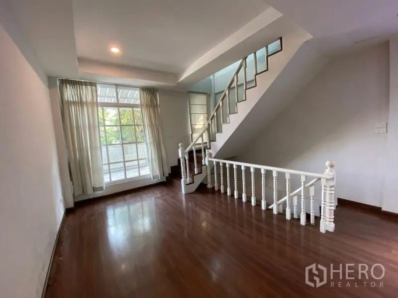 店屋 出租或出售在Watthana, Bangkok - 起居区设大窗采光与白色栏杆楼梯。