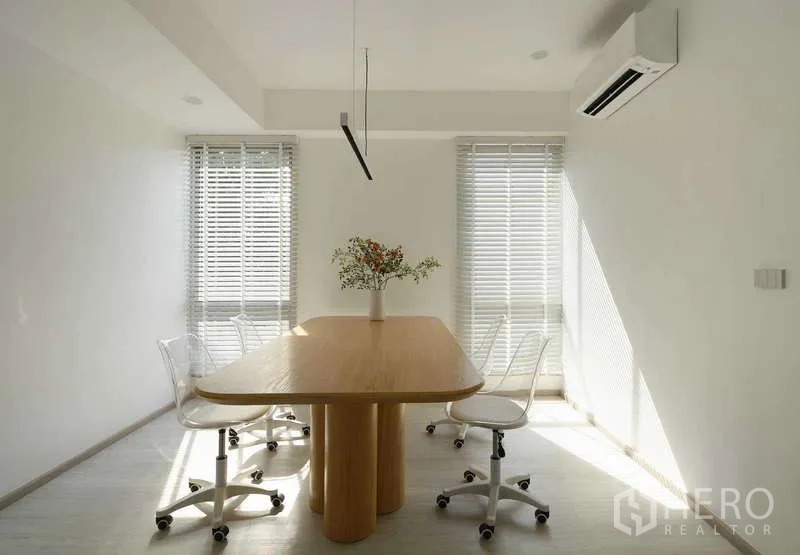 Home Office for sale in Chatuchak, Bangkok - Compact meeting room with wooden table, four white swivel chairs, blinds and air‑conditioning.