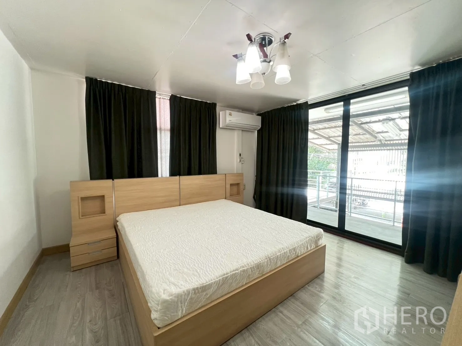 Detached House for rent or sale in Wang Thonglang, Bangkok - Bedroom with bed, blackout curtains, air conditioner and sliding glass door to balcony.