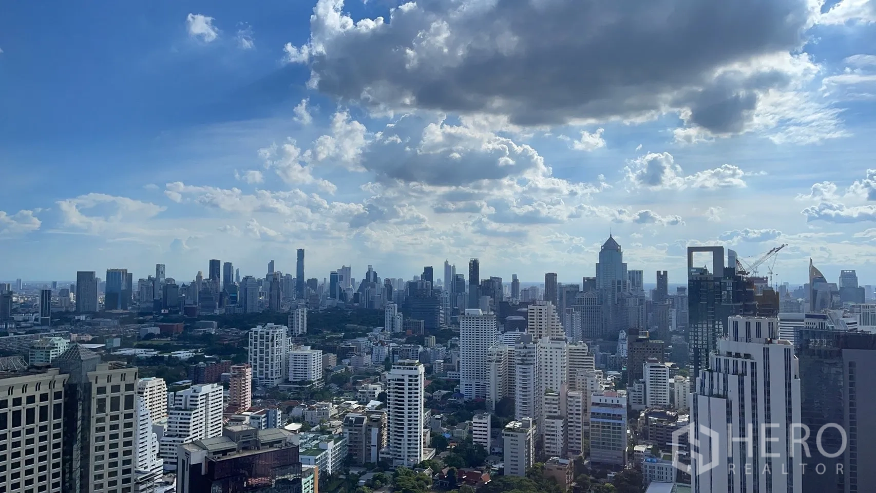 公寓 for rent in Watthana, Bangkok - 高楼层全景城市天际线，蓝天白云之下。