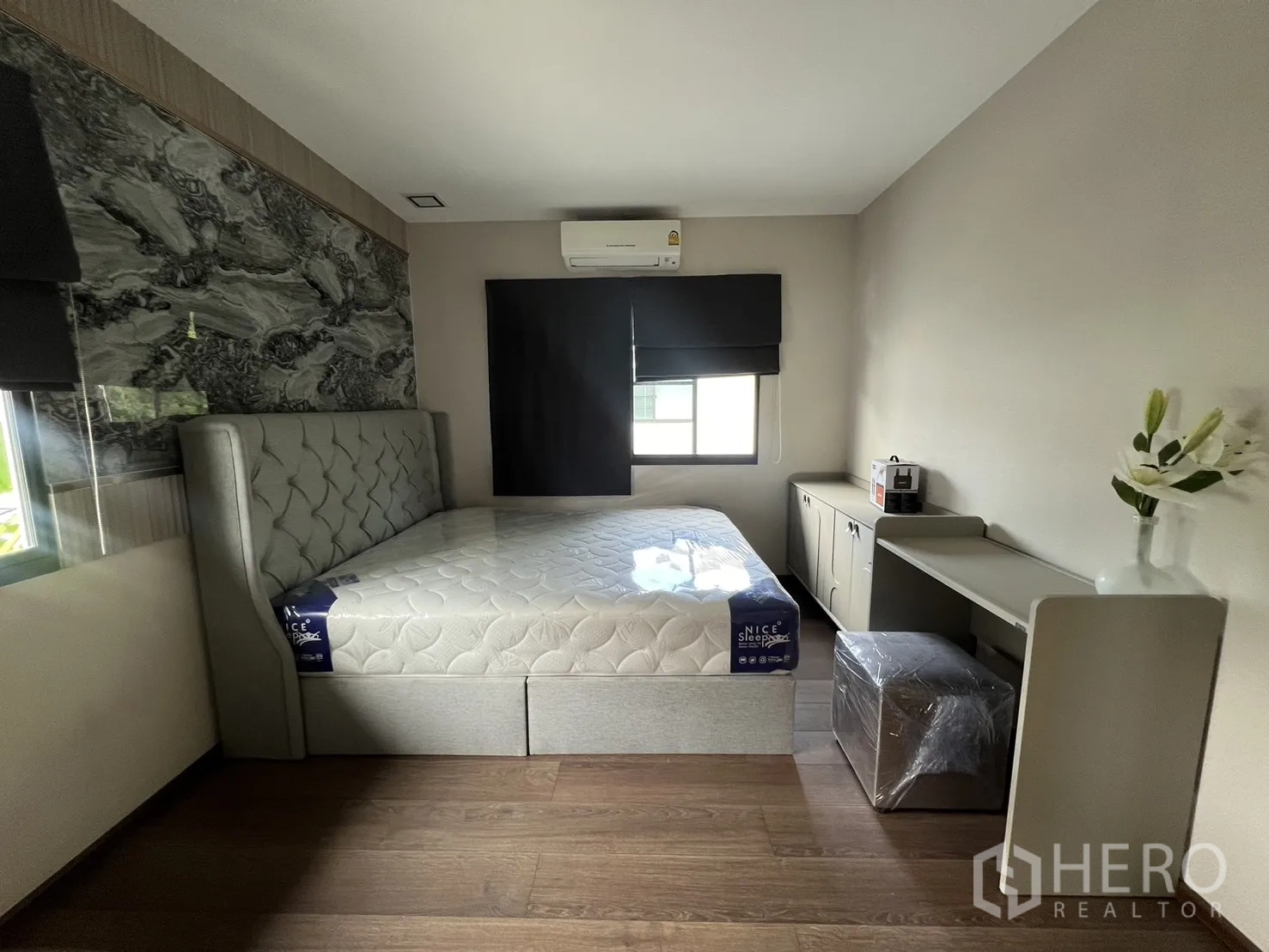 Detached House for rent in Bang Phli, Samut Prakan - Furnished bedroom with upholstered bed, feature wall and small desk.