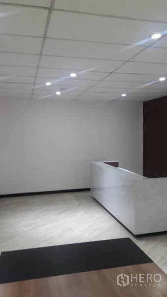 办公空间 出租在Huai Khwang, Bangkok - 明亮前台区，吊顶嵌灯与白色石材接待台的办公室。