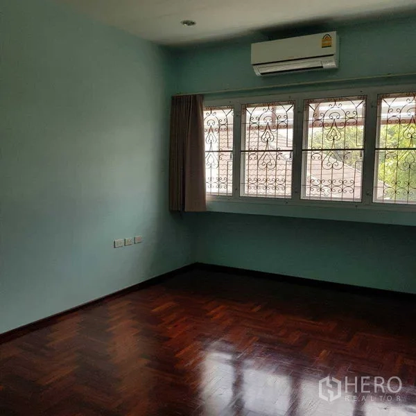 Home Office for rent in Watthana, Bangkok - Air-conditioned bedroom with three windows and decorative security grilles.