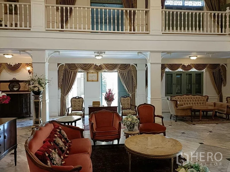 Detached House for rent or sale in Krathum Baen, Samut Sakhon - Ground-floor lounge with classic drapes, sofas and tall shuttered windows.