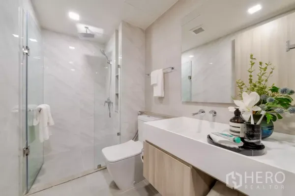 คอนโด ให้เช่าในWatthana, Bangkok - ห้องน้ำสว่าง พร้อมตู้กระจกกั้นอาบน้ำ เคาน์เตอร์อ่างล้างหน้าแบบติดผนัง และกระเบื้องลายหินอ่อน