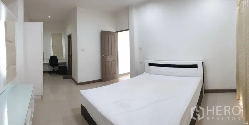 Detached House for rent in Khlong Toei, Bangkok - Master bedroom with large bed, desk nook, wardrobe and abundant natural light.