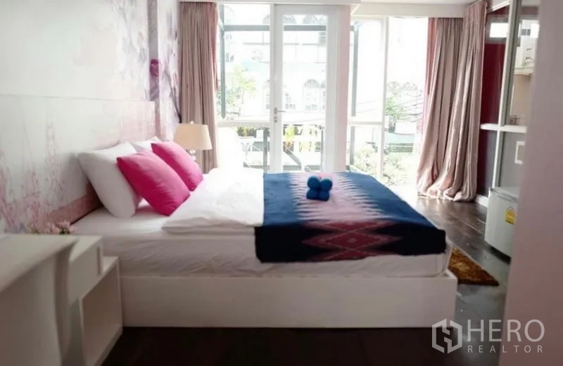 ทาวน์เฮาส์ ให้เช่าในKhlong Toei, Bangkok - ห้องนอนเตียงใหญ่ หมอนสีชมพู พร้อมประตูกระจกเปิดรับแสงธรรมชาติ