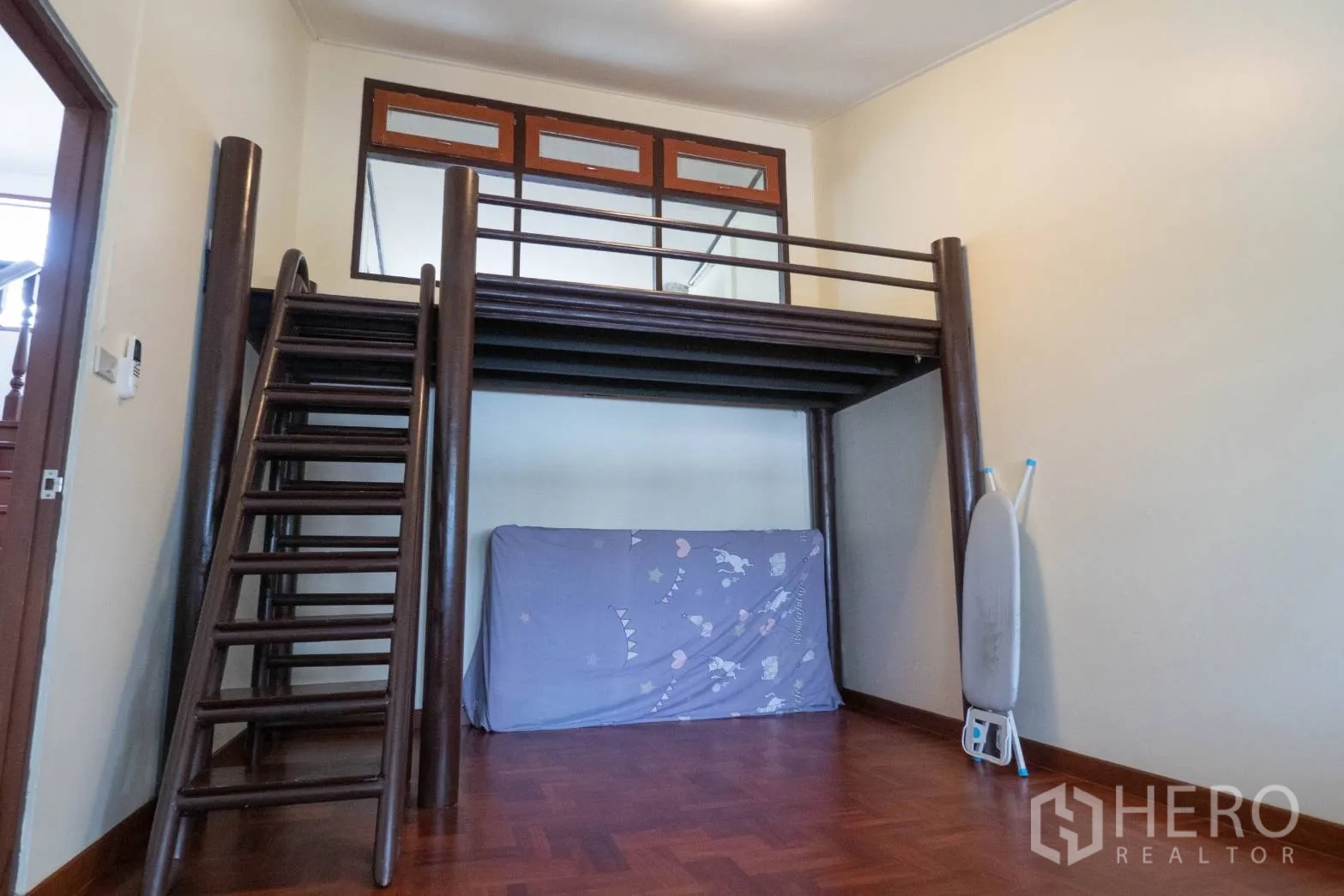 Townhouse for rent in Khlong Toei, Bangkok - Room featuring a high wooden loft bed with ladder and raised platform.