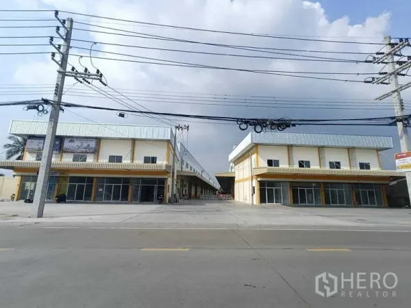 Warehouse for rent in Krathum Baen, Samut Sakhon - Street view of twin warehouse blocks with wide driveway and glass-front offices in Krathum Baen.
