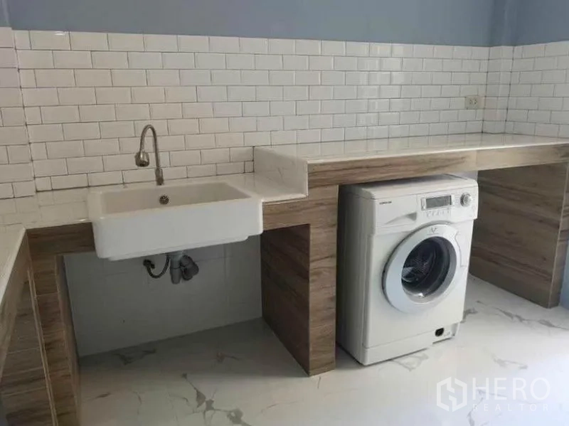 Detached House for rent in Wang Thonglang, Bangkok - Utility room alternate view showing built-in counters, deep sink, and front-load washer.