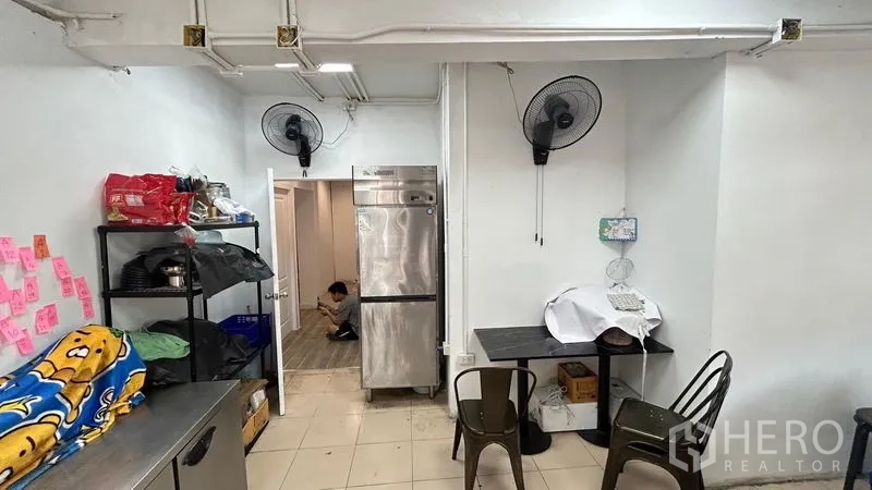 Shophouse for sale - Kitchen prep room with refrigerator, shelving and tile floor.