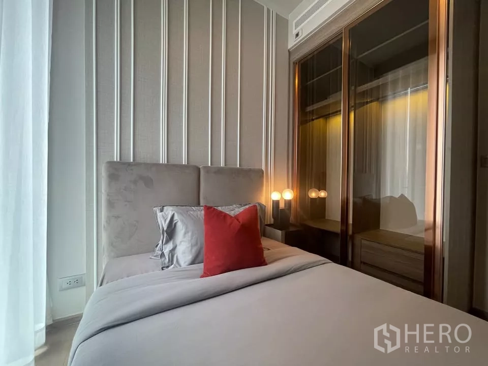 Condominium for rent in Watthana, Bangkok - Second bedroom with upholstered headboard and glass-front wardrobes.