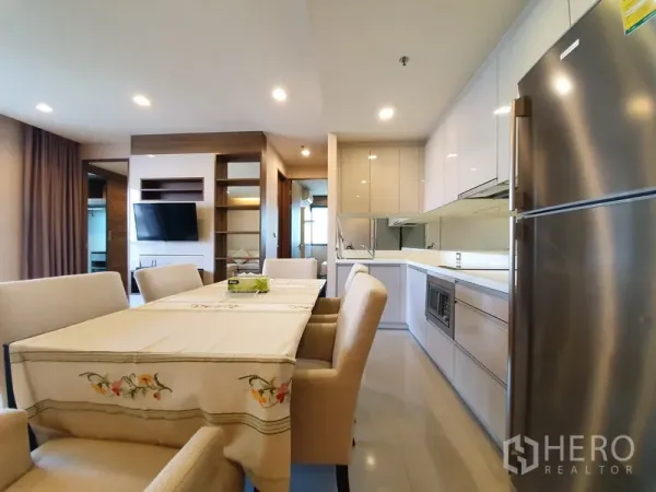公寓 出租在Bang Rak, Bangkok - 明亮的内置厨房，带不锈钢冰箱与餐区，顶置筒灯照明