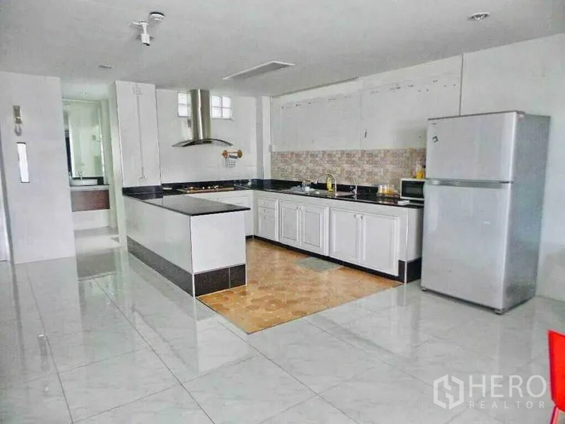 带办公室的家 出租或出售在Din Daeng, Bangkok - 宽敞厨房，白色橱柜，中岛灶台，瓷砖地面与不锈钢冰箱。