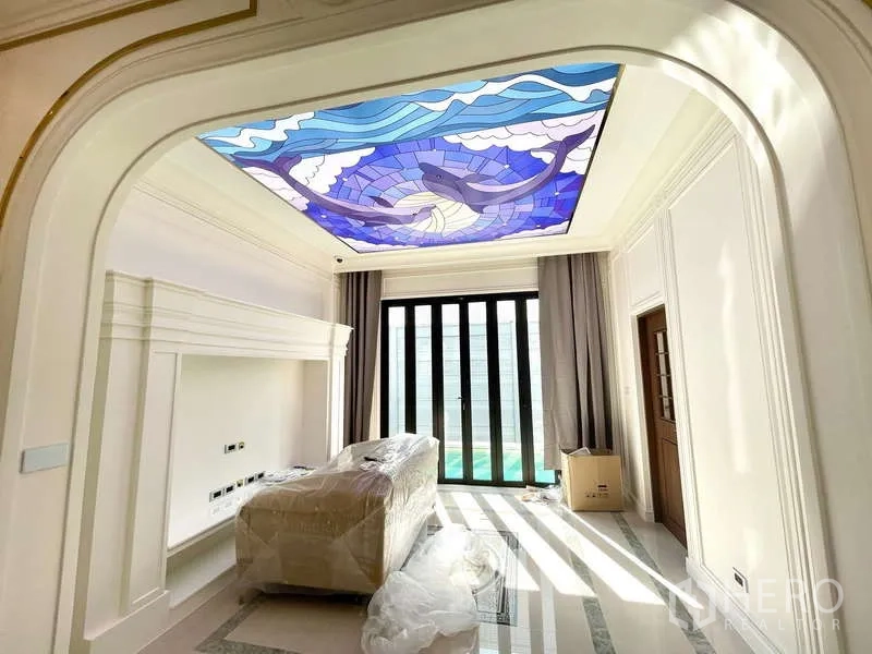 Detached House for sale in Thawi Watthana, Bangkok - Family room with stained-glass ceiling art and sliding doors opening to the pool