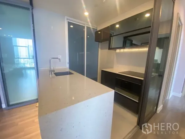 公寓 出租在Bang Rak, Bangkok - 现代厨房，长石英台中岛配水槽与电磁炉。
