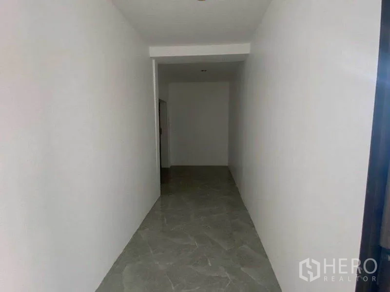 สำนักงาน ให้เช่าในWatthana, Bangkok - โถงทางเดินพื้นกระเบื้องสีเทา นำไปสู่ประตูกระจกทางเข้าสำนักงาน.