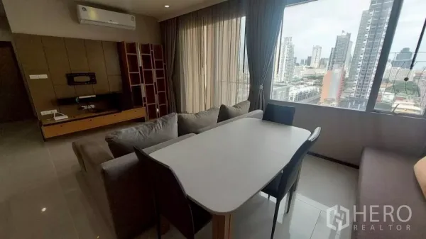 คอนโด ให้เช่าในKhlong San, Bangkok - โต๊ะทานข้าวข้างโซฟา หน้ากำแพงทีวี และหน้าต่างบานใหญ่เห็นวิวสกายไลน์