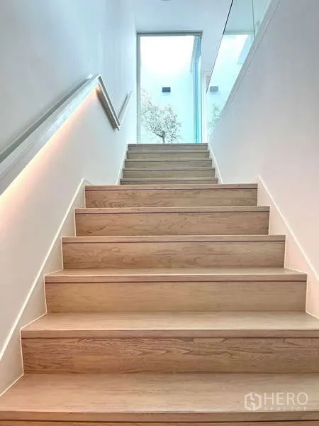 独立式住宅 出租或出售在Bang Phli, Samut Prakan - 宽木质楼梯，玻璃栏杆，大窗引入自然光。