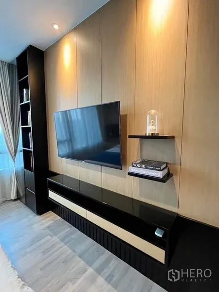 Condominium for sale in Bang Sue, Bangkok - Sleek TV wall with floating shelves and black-and-wood console beside tall window.