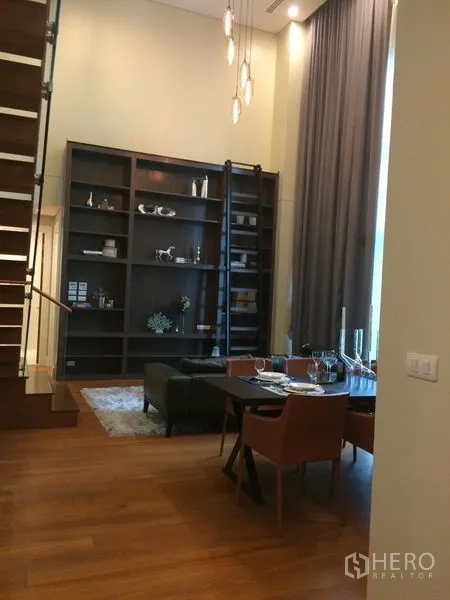 คอนโด ให้เช่าในKhlong Toei, Bangkok - โซนทานอาหารเพดานสูง มีบันไดไม้ โคมไฟห้อย และชั้นวางบิลต์อินเต็มผนัง