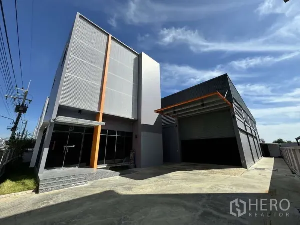 โรงงาน ให้เช่าหรือขายในLam Luk Ka, Pathum Thani - ด้านหน้าตัวอาคารมีประตูกระจกและลานขนถ่ายสินค้าพร้อมประตูม้วน