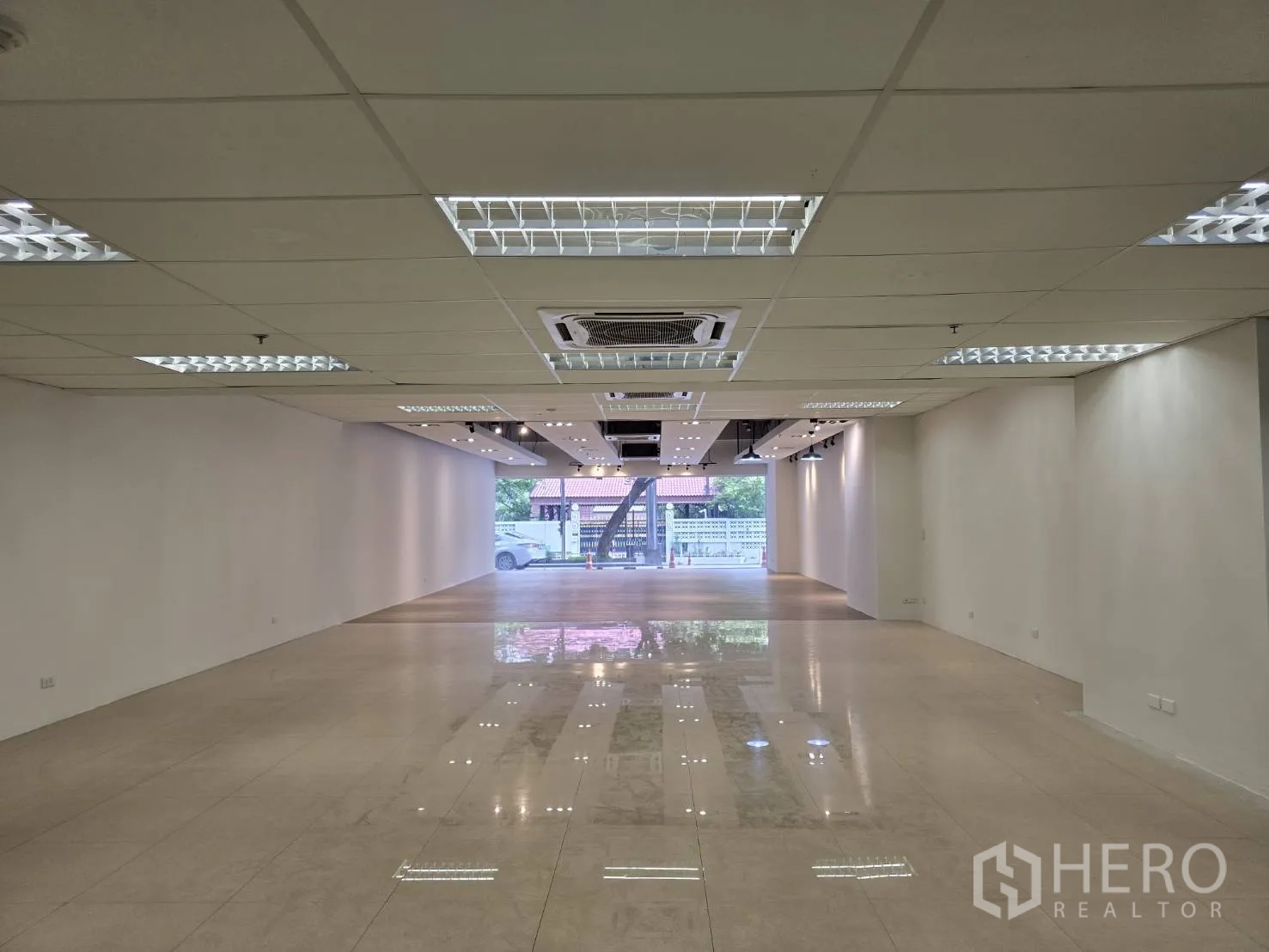 Retail Space for rent in Watthana, Bangkok - Large open-plan showroom with glossy floor, white walls, and ceiling lights.