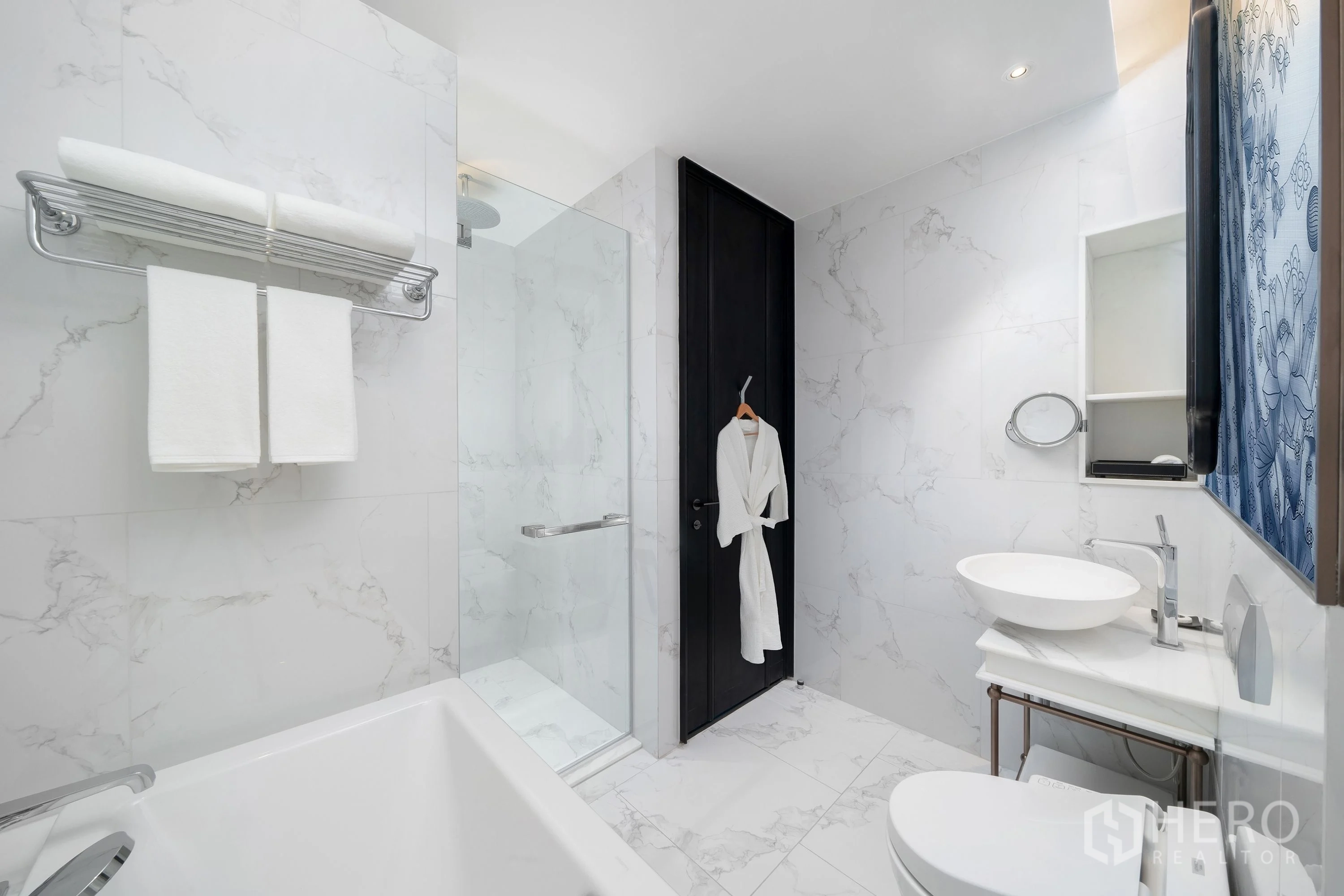 Condominium for rent in Khlong Toei, Bangkok - Marble bathroom view with separate glass shower, bathtub, vanity, and towel rack.