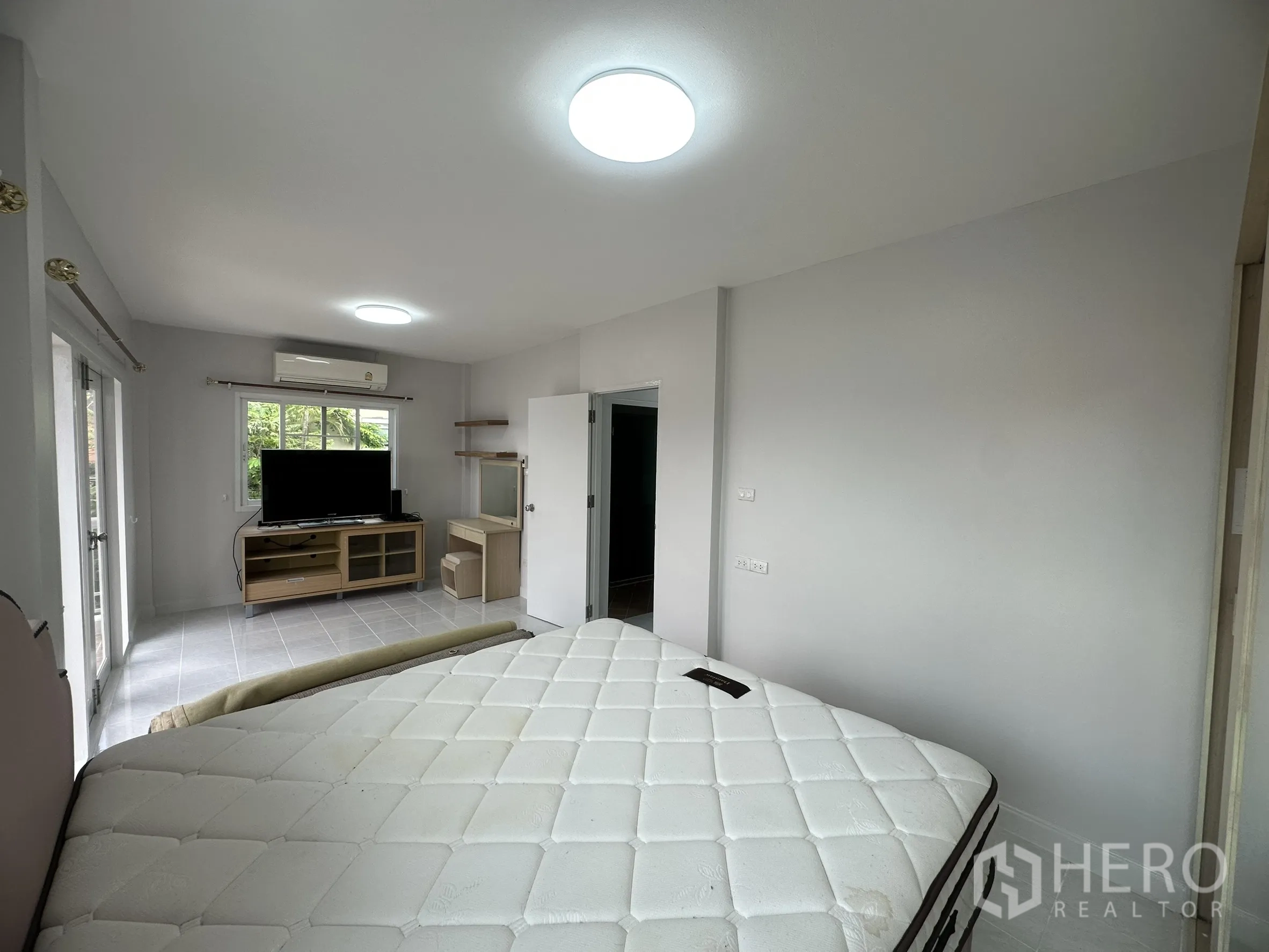 ทาวน์เฮาส์ ขายในLam Luk Ka, Pathum Thani - ห้องนอนใหญ่มีประตูกระจกเปิดสู่ระเบียง พร้อมทีวีและแอร์