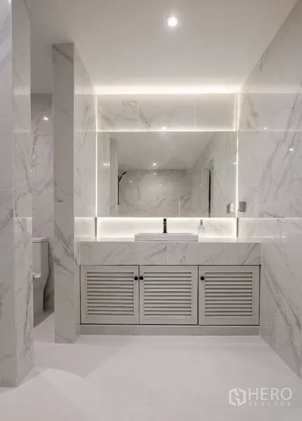 Condominium for sale - Marble bathroom vanity with backlit mirror and storage.