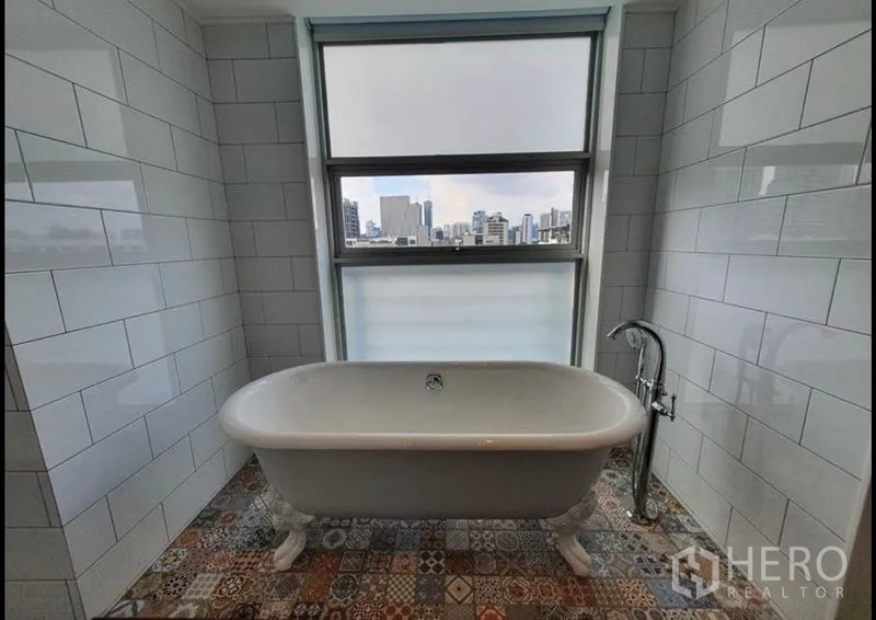 คอนโด ให้เช่าในWatthana, Bangkok - ห้องน้ำพร้อมอ่างอาบน้ำขาตั้งข้างหน้าต่าง มองเห็นสกายไลน์กรุงเทพฯ